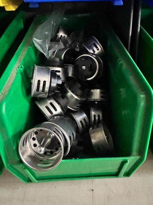 Assorted metal vented cylindrical housings in a green bin